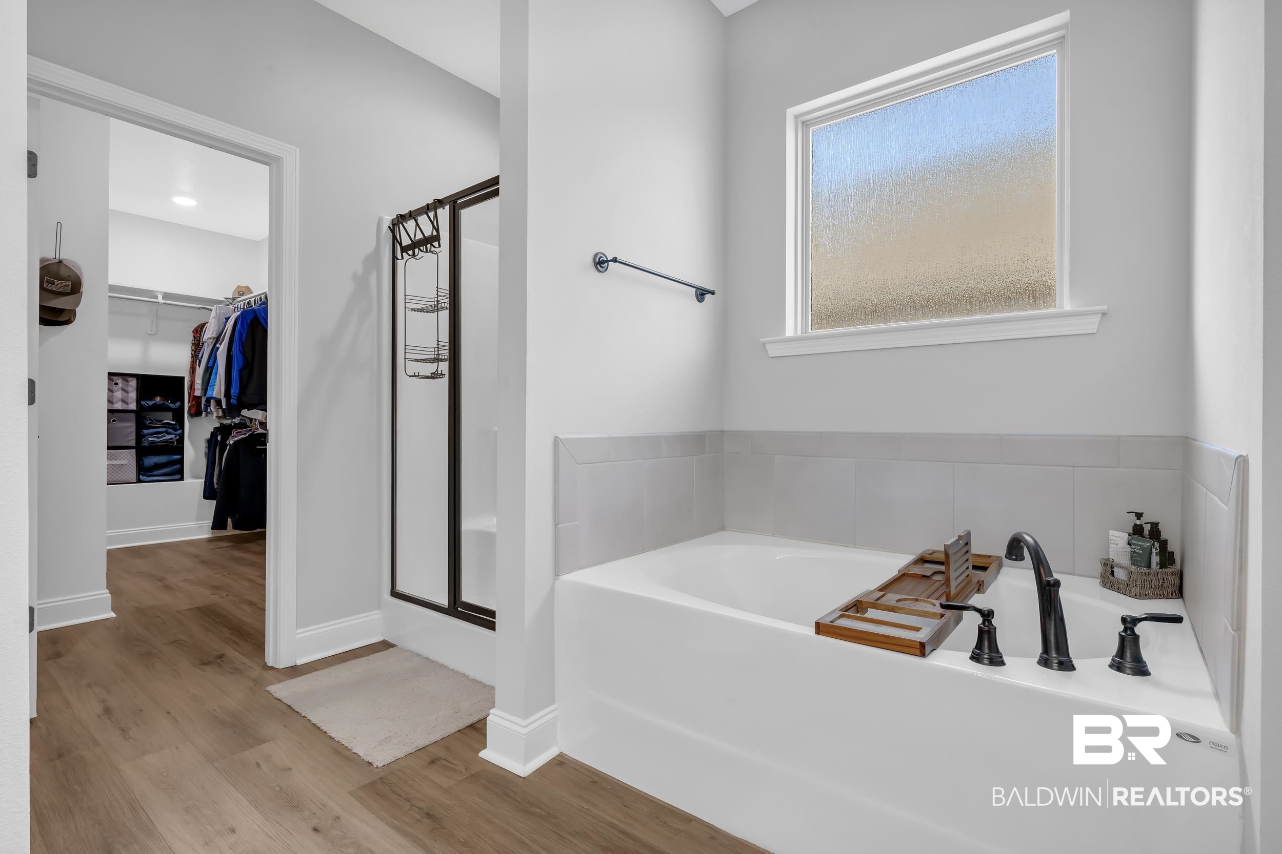 1176 Stella Road Foley, AL 36535 - Photo 21 of 40 Bathroom featuring a walk in closet, a bath, a stall shower, and light wood-style floors