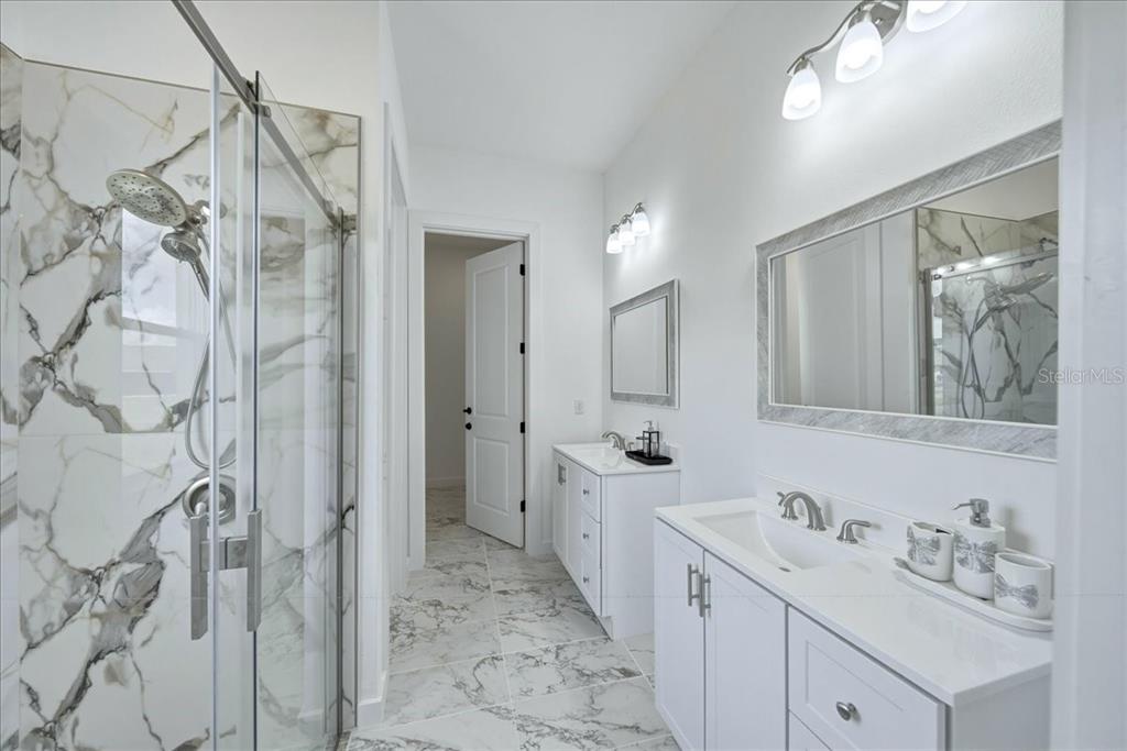 1215 Rio De Janeiro Avenue Punta Gorda, FL 33983 - Photo 45 of 65 a bathroom with a double vanity sink mirror and shower