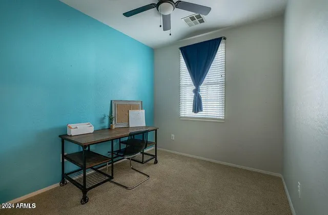 a view of a workspace with furniture and a window