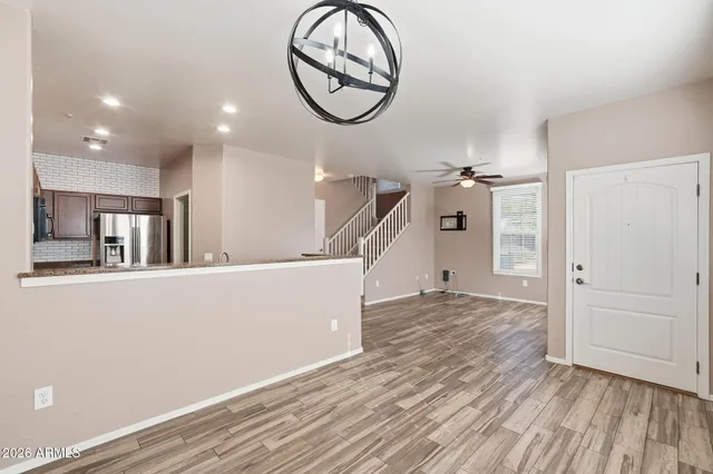 a view of a livingroom with wooden floor and a ceiling fan