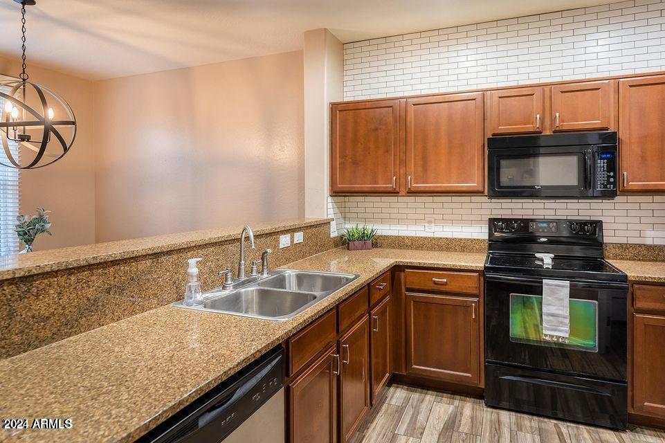 4757 East Waterman Street, Unit 103 Gilbert, AZ 85297 - Photo 8 of 27 a kitchen with stainless steel appliances granite countertop a sink stove and microwave