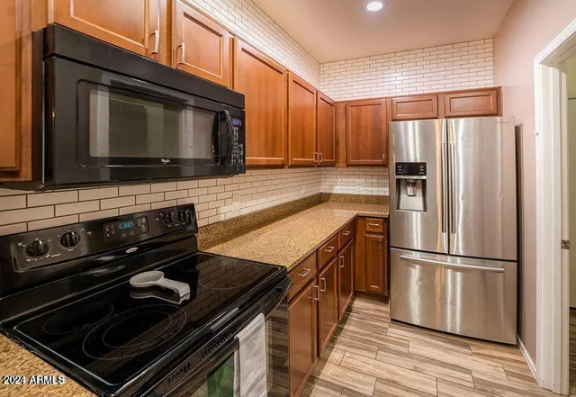 a kitchen with wooden cabinets and stainless steel appliances