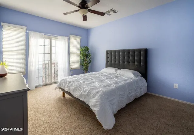 a large bed sitting in a spacious bedroom next to a window