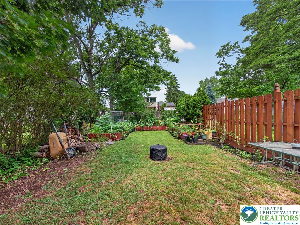 425 Ridge Street Emmaus, PA 18049 - Photo 27 of 27 A private, tree-lined yard with a manicured lawn and vibrant garden beds.