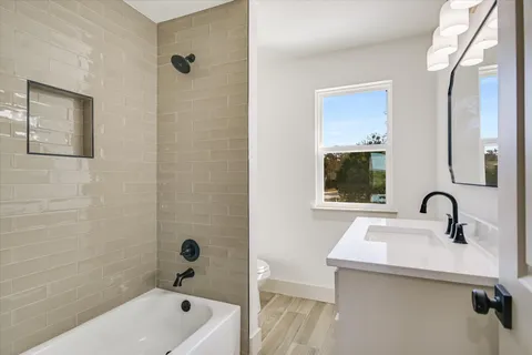 a bathroom with a sink a mirror a bathtub and shower