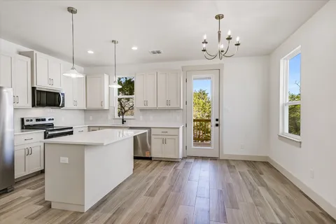 a kitchen with a sink window and stainless steel appliances