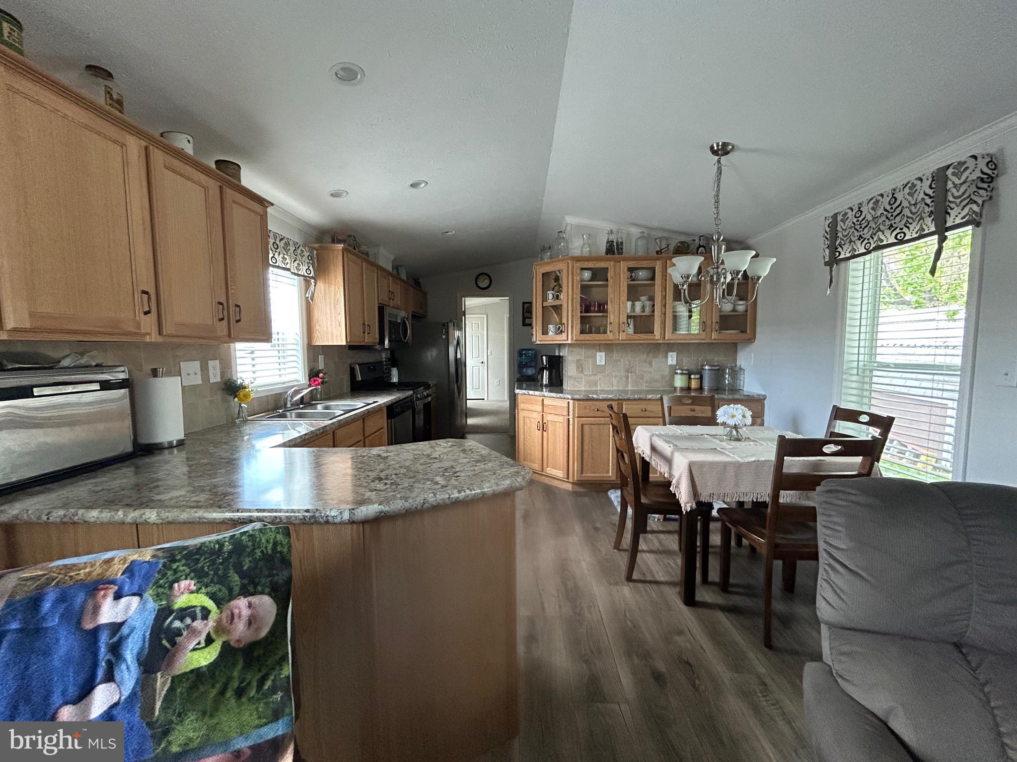 18 Jade Drive Lititz, PA 17543 - Photo 23 of 39 a kitchen with stainless steel appliances granite countertop a stove top oven a sink a dining table and chairs with wooden floor