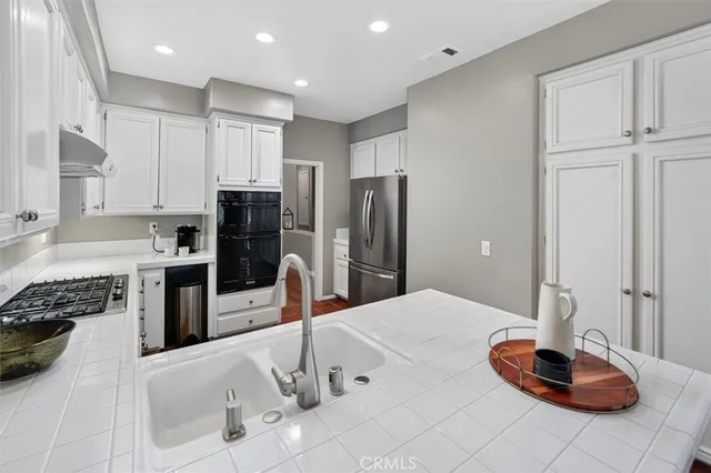 a kitchen with stainless steel appliances kitchen island granite countertop a refrigerator and a stove top oven