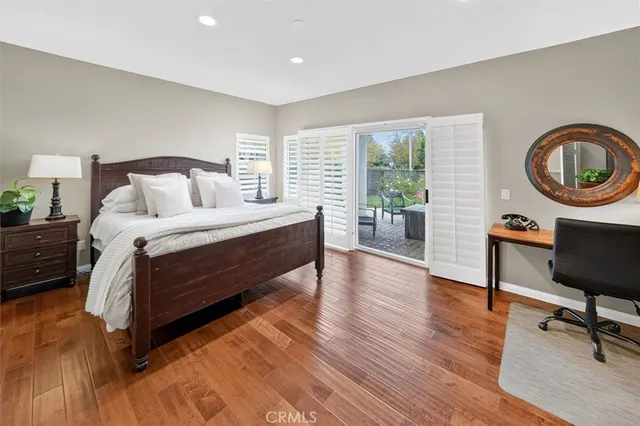 a bedroom with a bed a table and chair with a large window