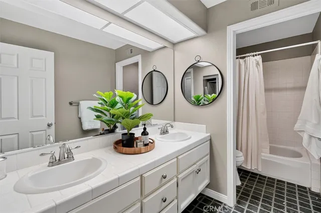 a bathroom with a double vanity sink and a mirror