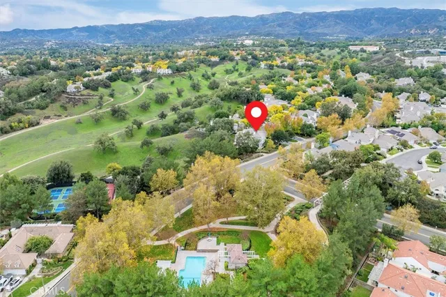 a view of a lush green field with mountains in the background