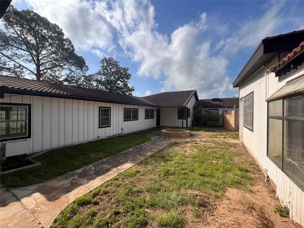 a view of a house with backyard and sitting area