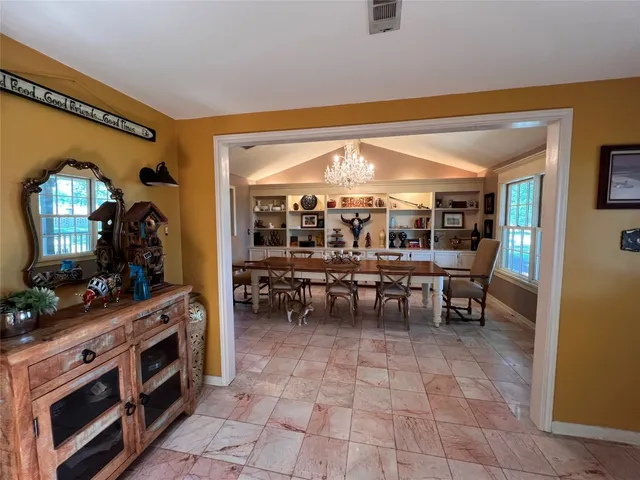 a view of a dining room with furniture and chandelier