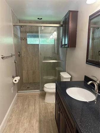 a bathroom with a sink toilet a mirror and shower