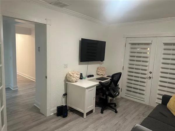 a view of a workspace with furniture and wooden floor