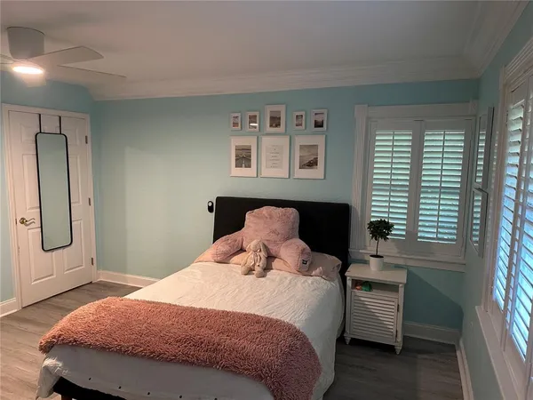 a bedroom with a bed and wooden floor