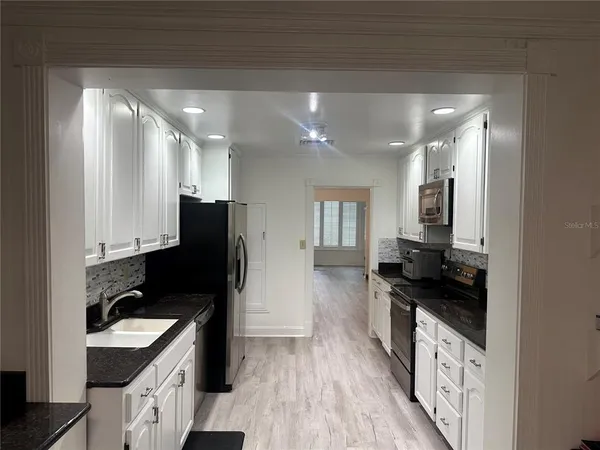 a kitchen with granite countertop a stove and a refrigerator
