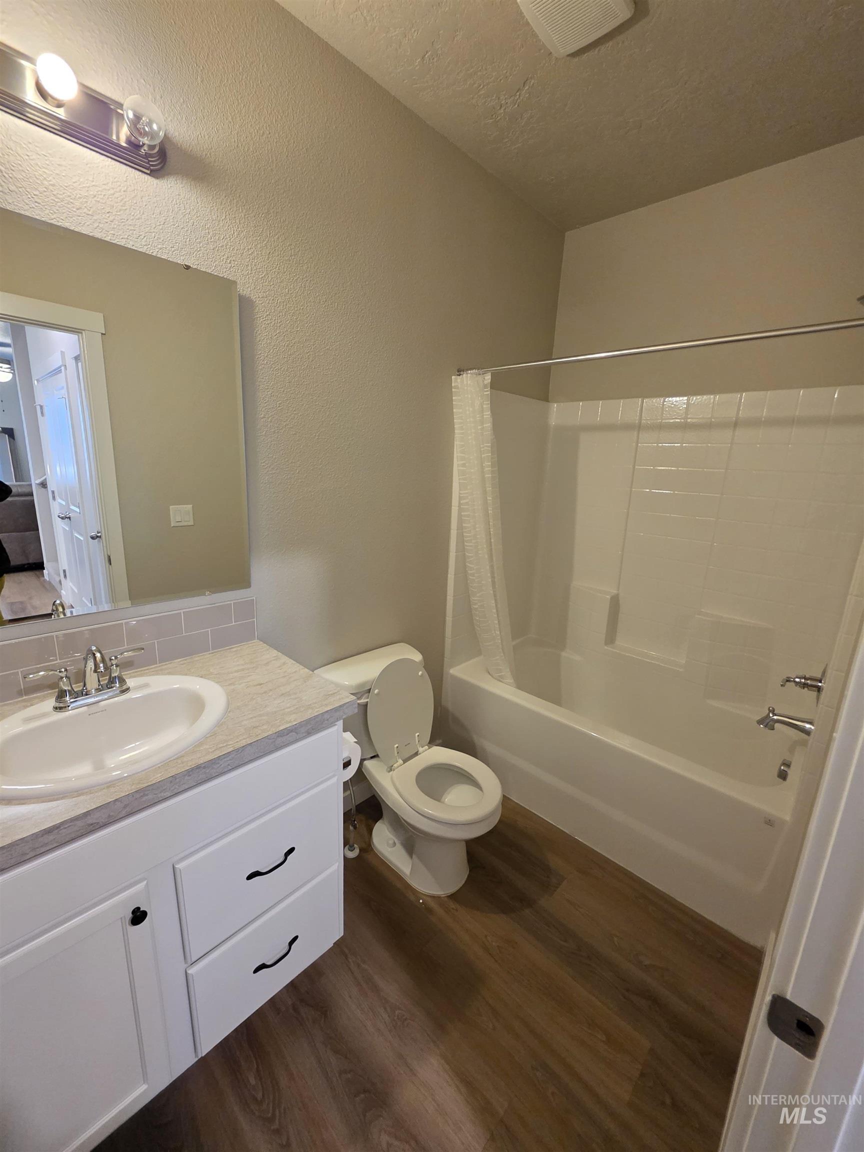 2316 East Spice Loop, Unit 4 Nampa, ID 83687 - Photo 12 of 12 Full bath with shower / bath combo, vanity, dark wood-style floors, a textured ceiling, and a textured wall