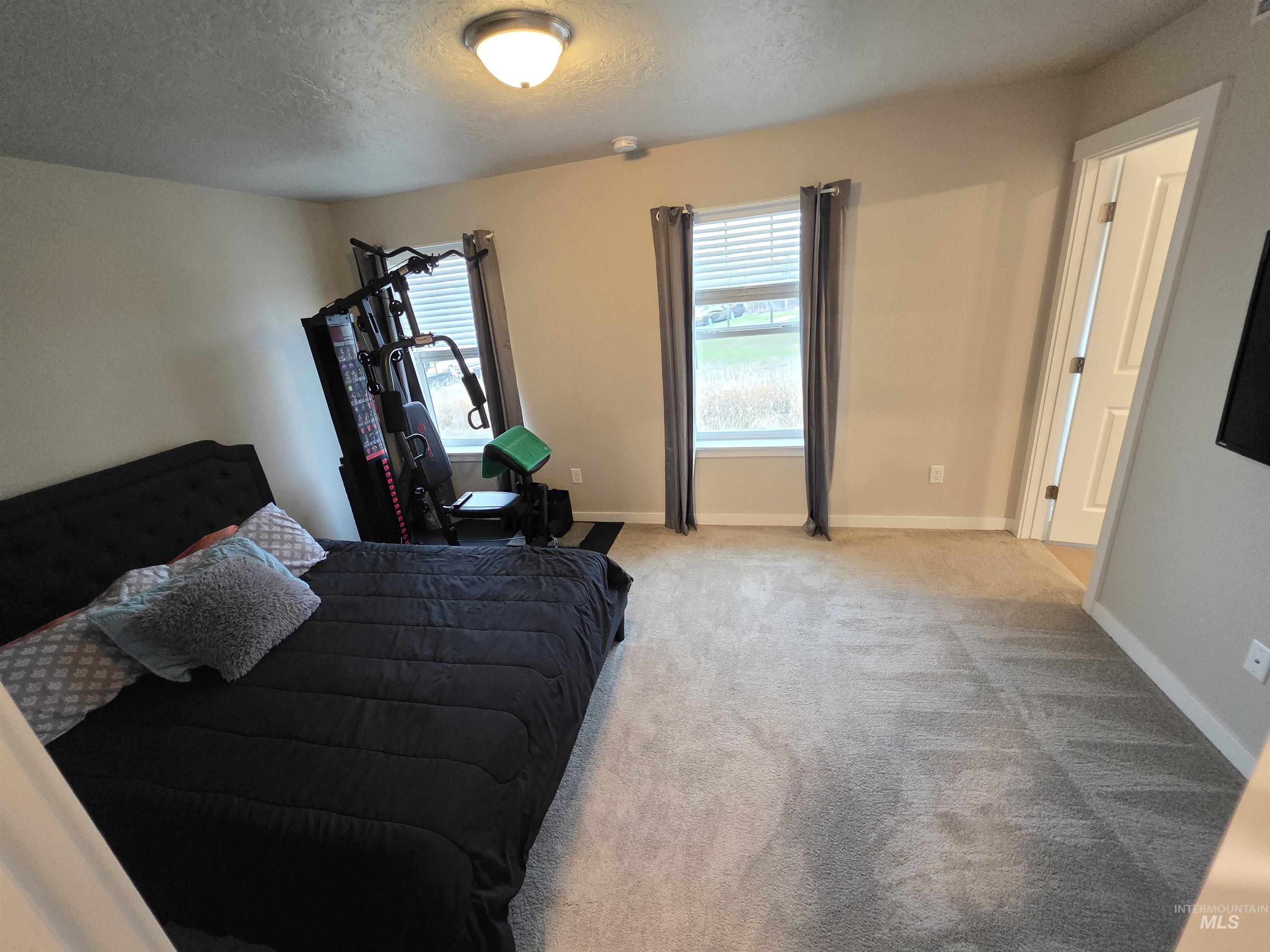 2316 East Spice Loop, Unit 4 Nampa, ID 83687 - Photo 6 of 12 Bedroom featuring a textured ceiling and carpet