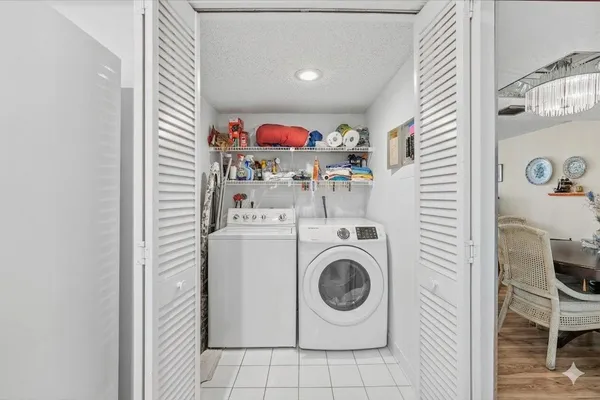 a dining room with wooden floor a chandelier a glass table and chairs