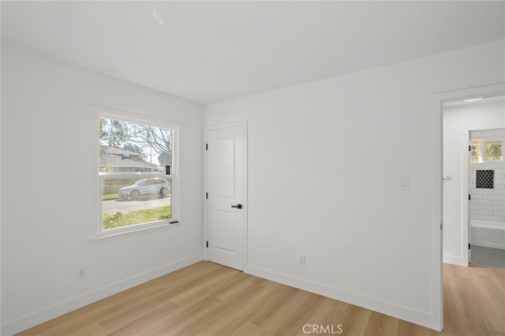 1290 Lomita Road San Bernardino, CA 92405 - Photo 13 of 29 a view of an empty room with window and wooden floor