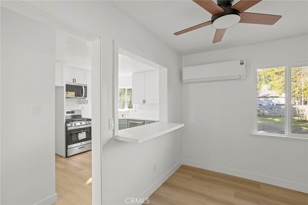 1290 Lomita Road San Bernardino, CA 92405 - Photo 8 of 29 wooden floor in an empty room with a window and a kitchen
