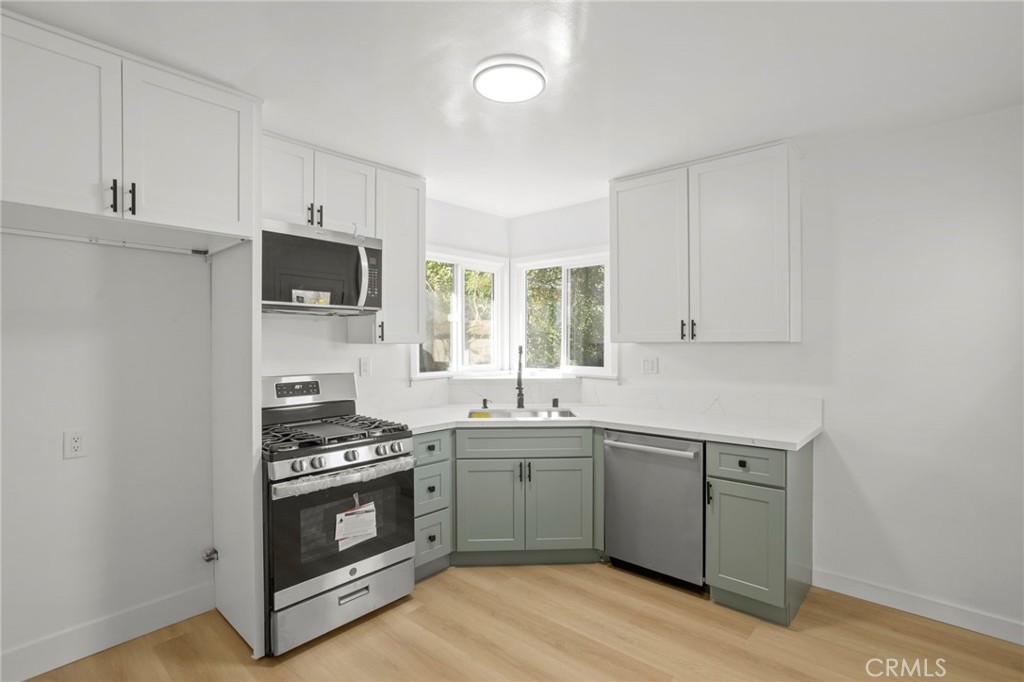 1290 Lomita Road San Bernardino, CA 92405 - Photo 9 of 29 a kitchen with stainless steel appliances a sink cabinets and a window