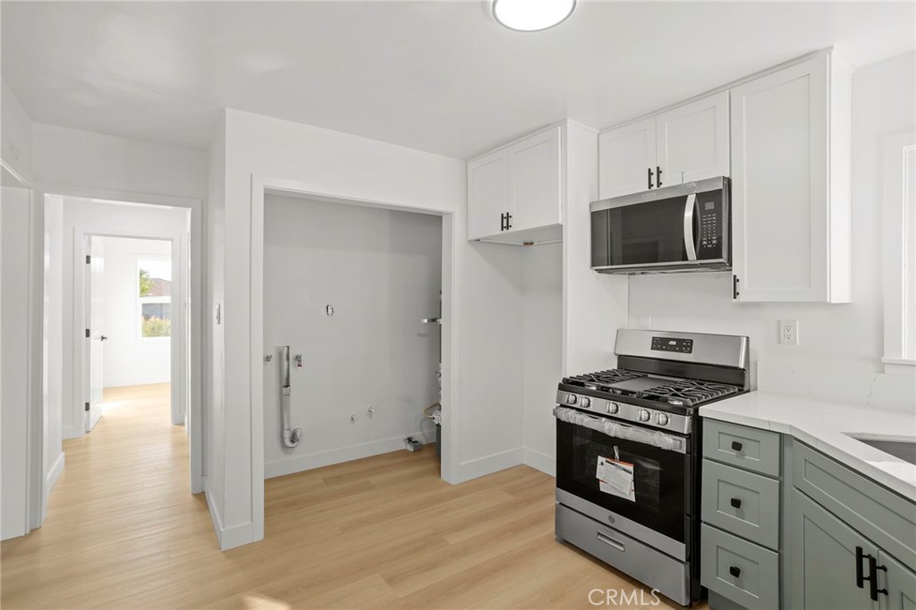 1290 Lomita Road San Bernardino, CA 92405 - Photo 10 of 29 a kitchen with cabinets stainless steel appliances and wooden floor