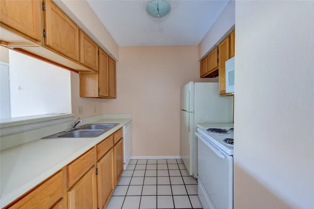 a kitchen with a refrigerator and a stove top oven