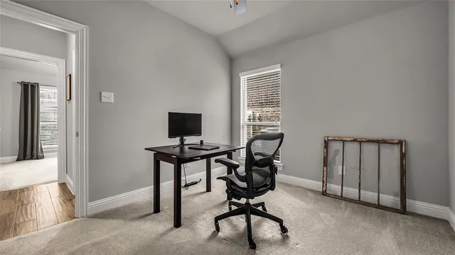 a view of a workspace with furniture and a window
