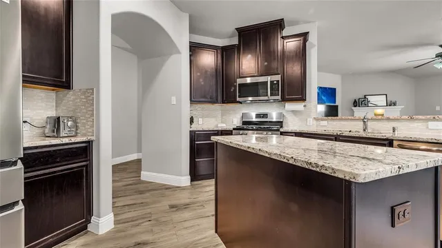 a kitchen with granite countertop stainless steel appliances and wooden cabinets