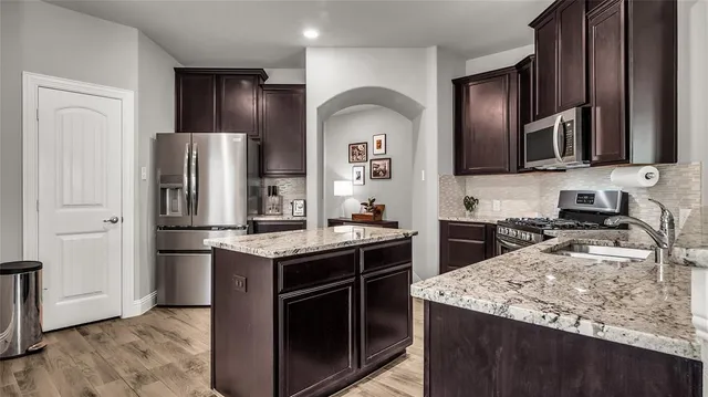 a kitchen with stainless steel appliances granite countertop a sink stove and refrigerator