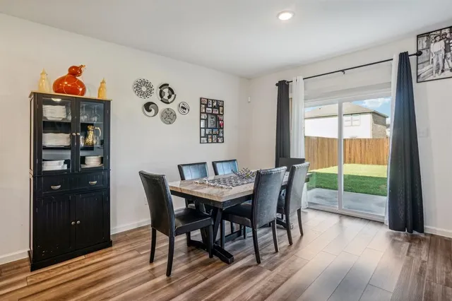 a view of a dining room with furniture a chandelier and wooden floor