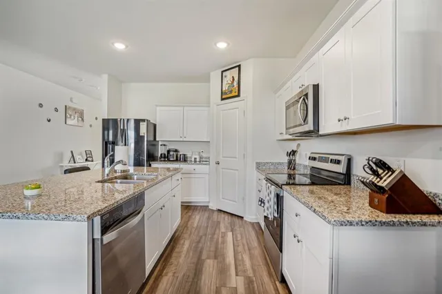 a kitchen with granite countertop a sink stove and cabinets