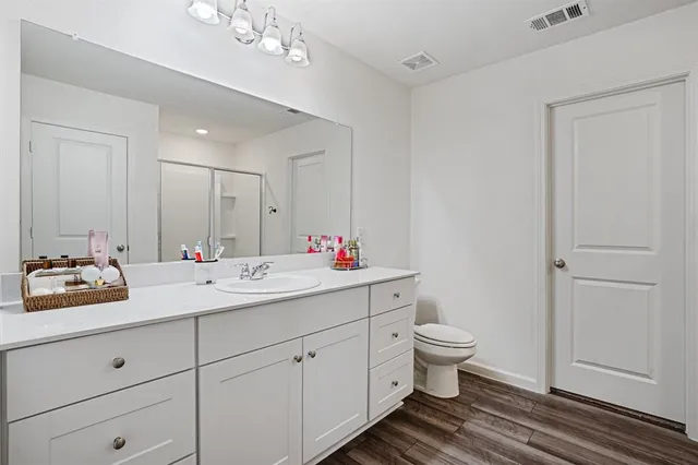 a bathroom with a double vanity sink mirror and toilet