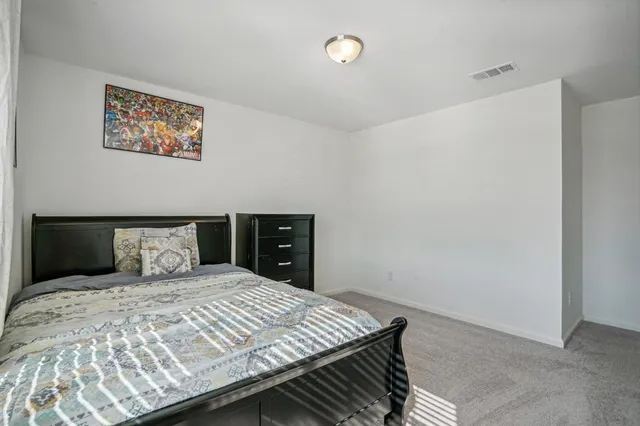 a bedroom with a bed and painting on the wall