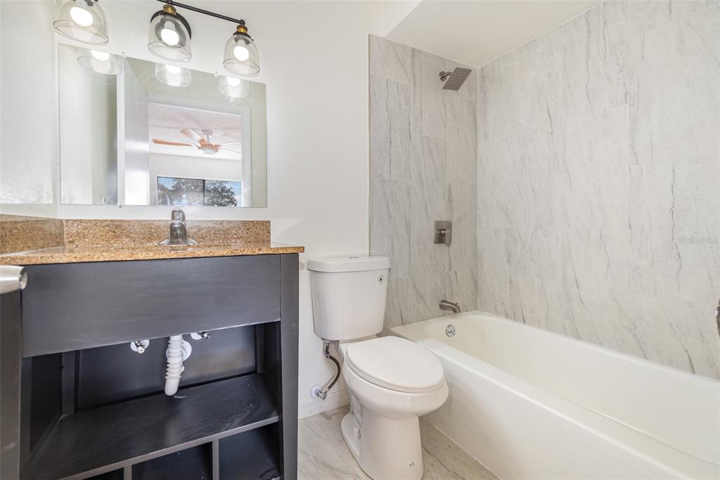 1000 Lake Of The Woods Boulevard, Unit E206 Fern Park, FL 32730 - Photo 13 of 17 a bathroom with a granite countertop sink a toilet and bathtub