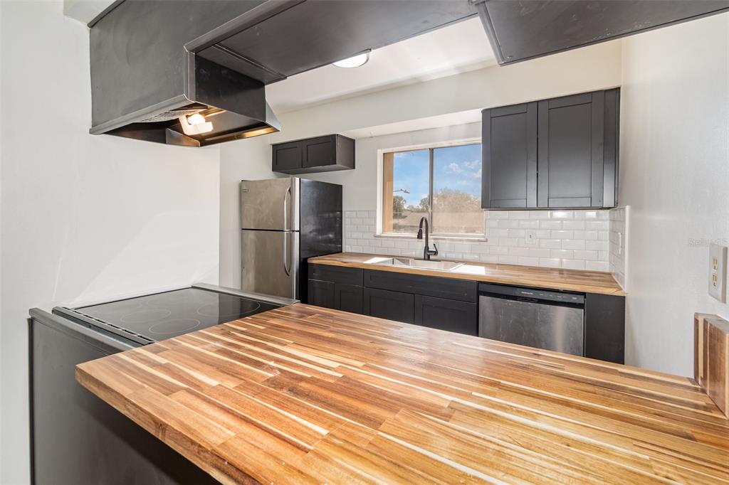 1000 Lake Of The Woods Boulevard, Unit E206 Fern Park, FL 32730 - Photo 2 of 17 a kitchen with kitchen island stainless steel appliances a sink stove and refrigerator
