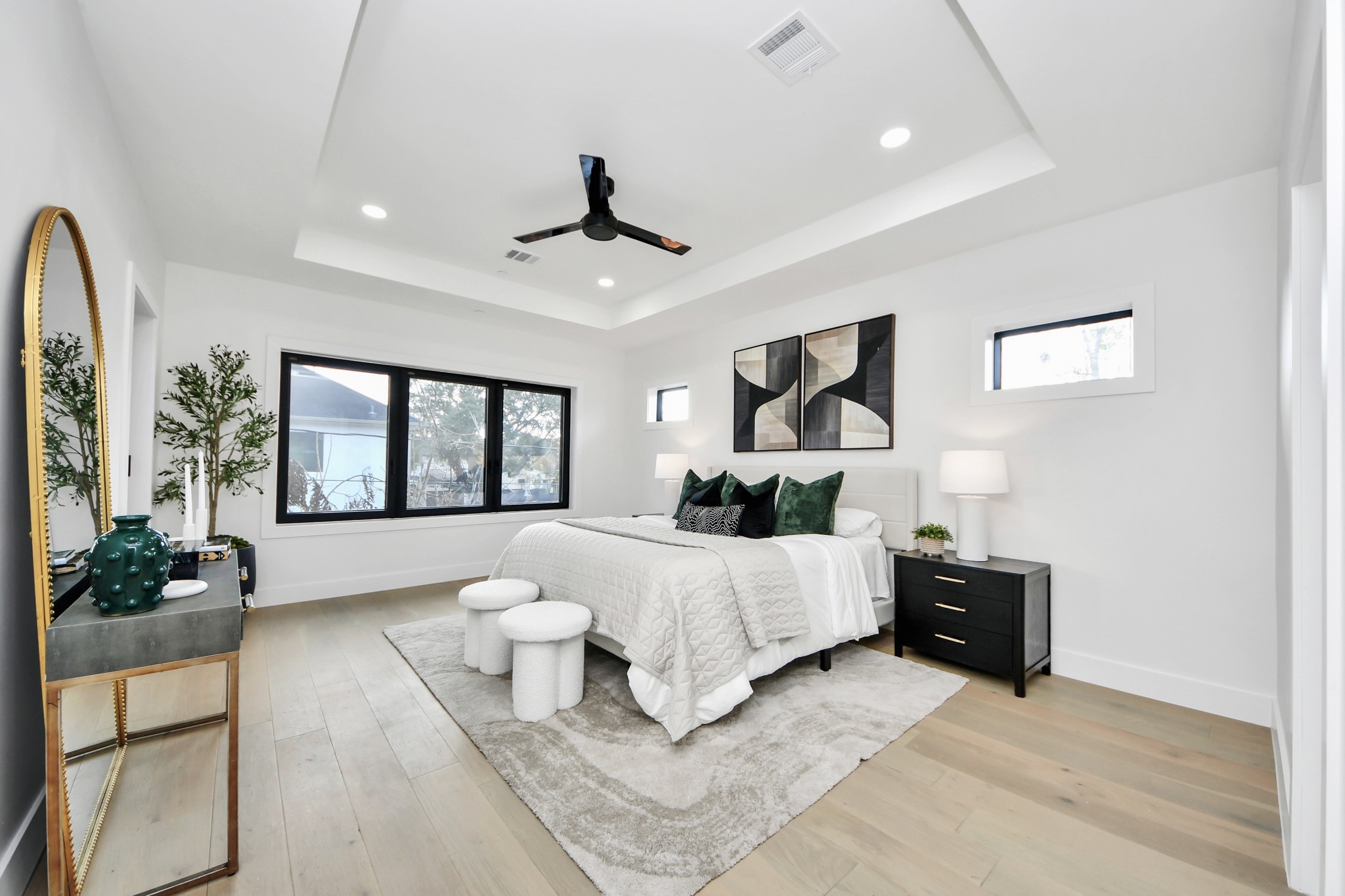 5115 Maple Street Bellaire, TX 77401 - Photo 28 of 45 The primary bedroom is a serene sanctuary. Expansive windows fill the space with natural light, highlighting the refined finishes, neutral palette, and subtle architectural details that create a sense of calm and luxury.
