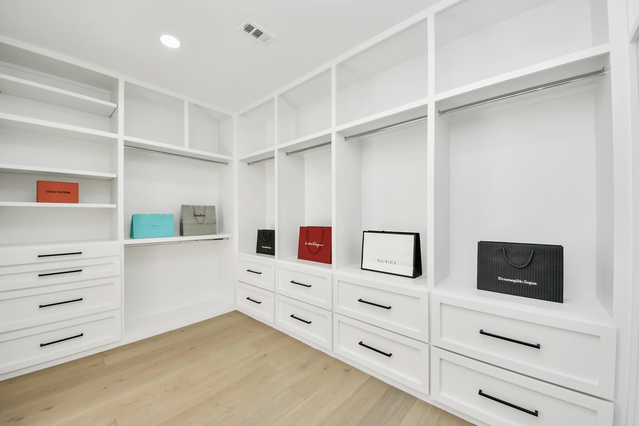 5115 Maple Street Bellaire, TX 77401 - Photo 33 of 45 The primary closet is a masterclass in organization and luxury, featuring custom cabinetry with built-in drawers that keep wardrobe essentials neatly stored and easily accessible.