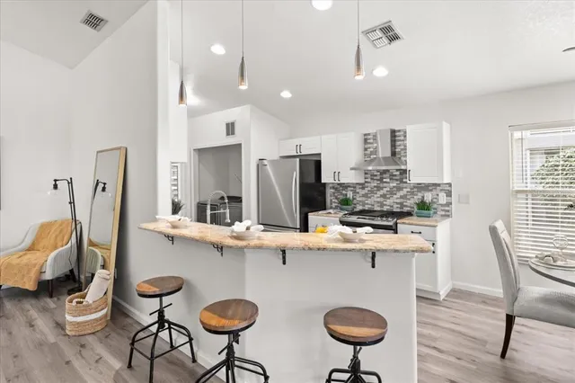 a kitchen with stainless steel appliances granite countertop a sink and a refrigerator