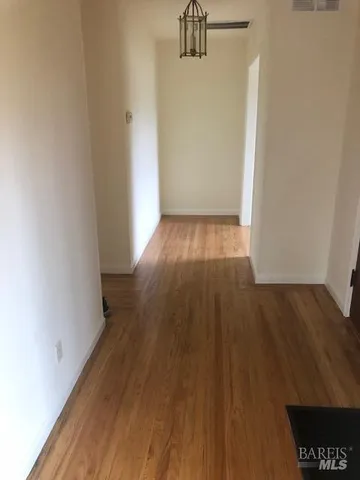 a view of a room with wooden floor and a window
