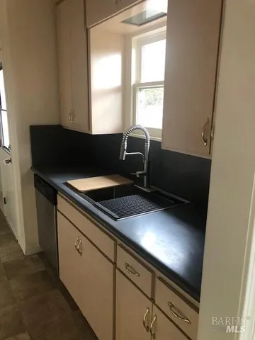 a kitchen with a sink cabinets and a window