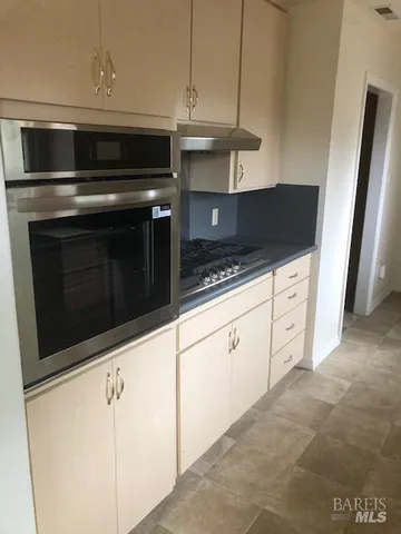 a kitchen with granite countertop white cabinets and black appliances