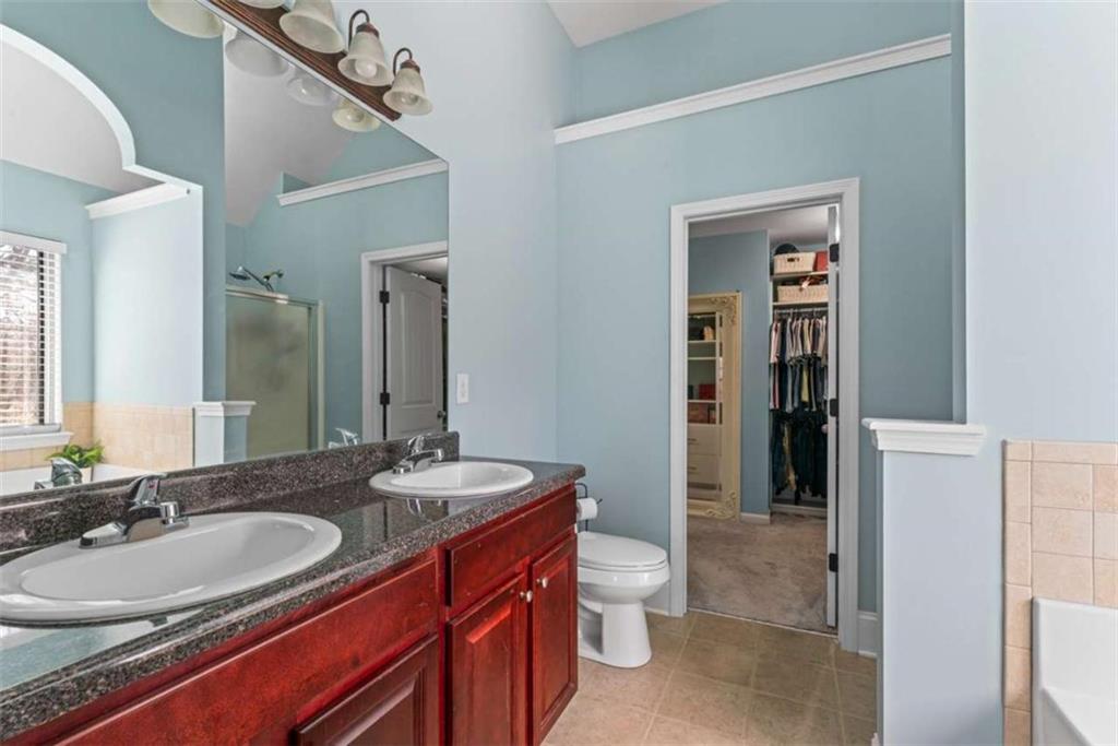 132 Luke Cove Hampton, GA 30228 - Photo 26 of 36 a bathroom with a granite countertop sink and a mirror