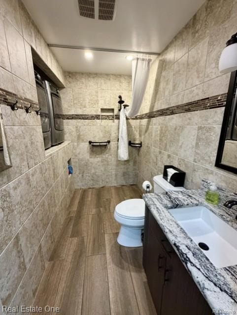 1115 Torpey Road Troy, MI 48083 - Photo 29 of 38 Full bathroom featuring vanity, tile walls, tiled shower, and recessed lighting