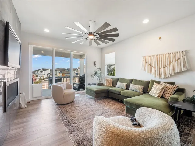 a living room with furniture a fireplace and a kitchen view