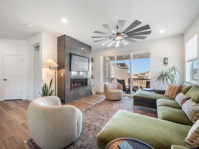 a living room with furniture a chandelier and a wooden floor