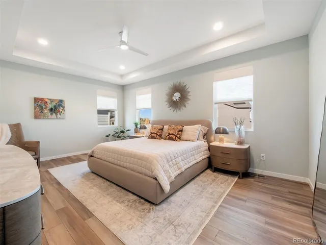 a spacious bedroom with a bed and wooden floor