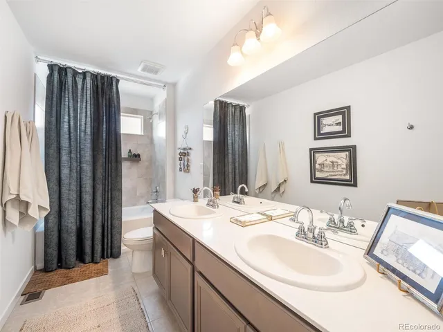 a en suite bathroom with a double vanity sink mirror and shower